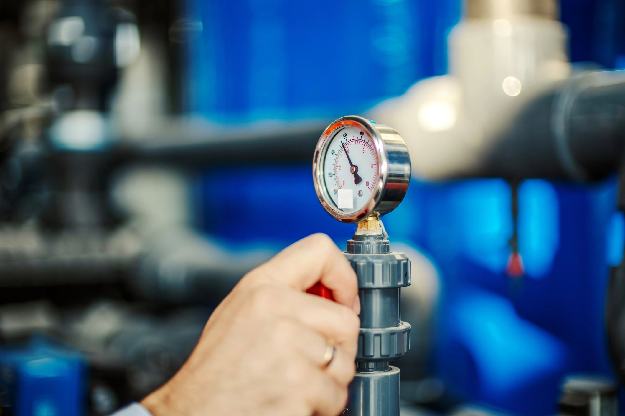 Technician hand adjusting pool equipment valves and pressure system
